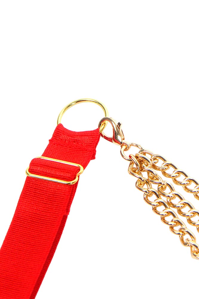 Γυναίκα που ποζάρει φορώντας το κόκκινο ανοιχτό σετ με αλυσίδες, σε πλήρη κάθετη λήψη.